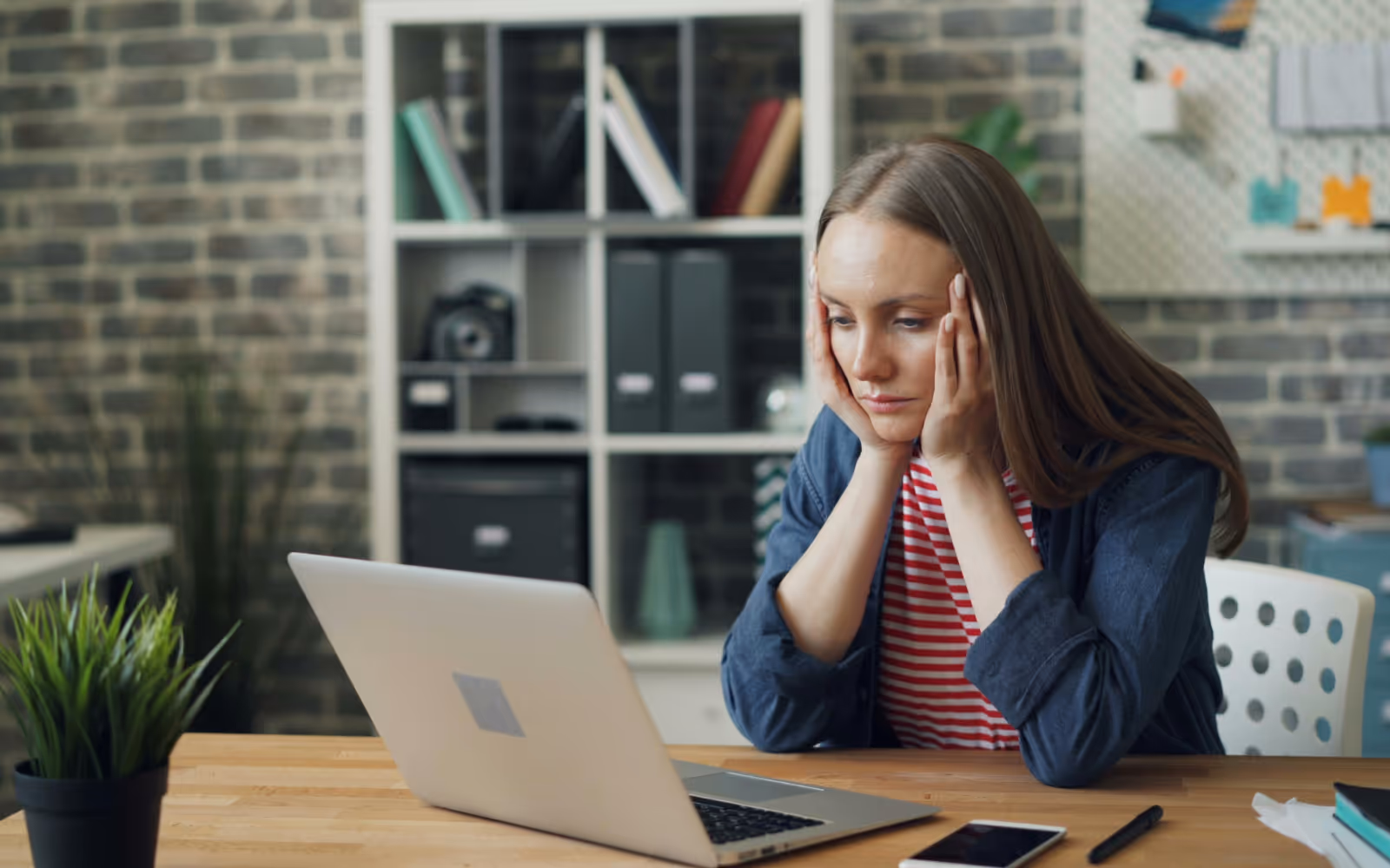 Small business owner looking concerned at laptop during cost of living crisis in Australia, exploring loyalty program solutions.